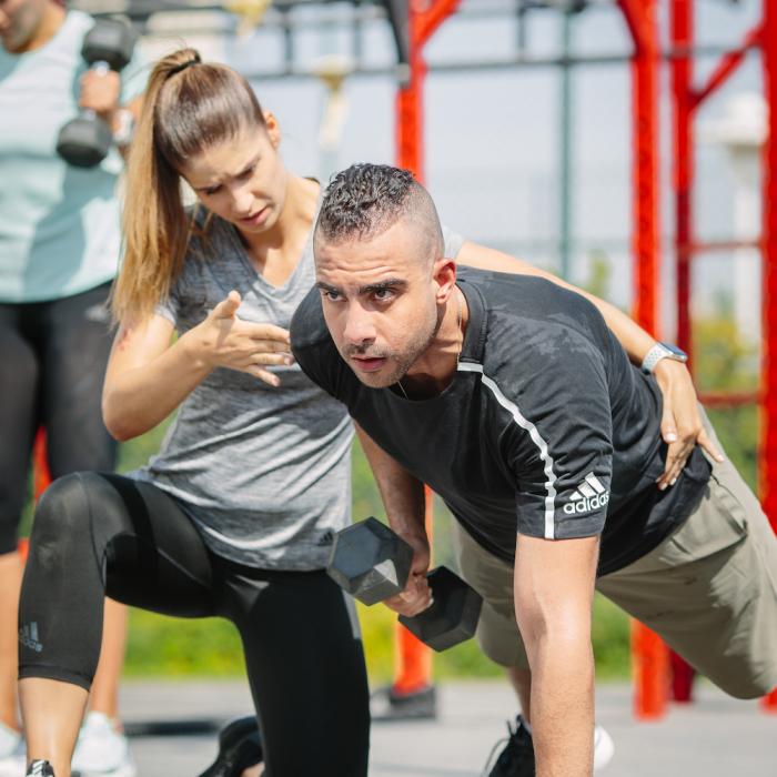 Personal trainer coaching on single arm dumbbell row Personal trainer coaching on single arm dumbbell row