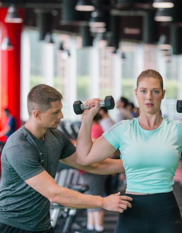 personal trainer coaching on dumbbells lifting personal trainer coaching on dumbbells lifting