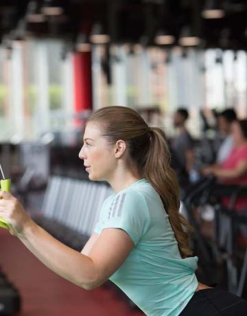 Lady performing triceps pull down exercise Lady performing triceps pull down exercise