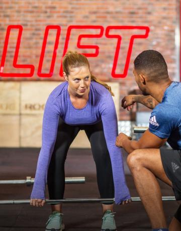 Xfit coach instructing a member on deadlift exercise Fitness First coach instructing a member on deadlift exercise