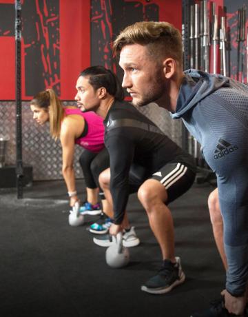 Fitness First members exercising using kettle bell Fitness First members exercising using kettle bell