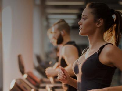 membership packages Female Gym member running on treadmill in Fitness First UAE
