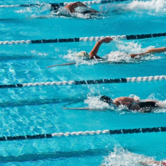 Fitness first members having a swimming race Fitness first members having a swimming race