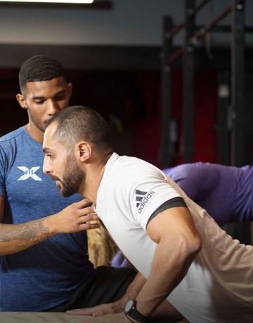 Xfit coach instructing a member Xfit coach instructing a member